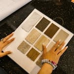 Businesswoman browsing stone samples in office for project evaluation.