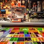 Vibrant workshop scene featuring a 3D printer, organized tools, and colorful storage containers.