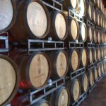 Wooden wine barrels in a Napa, CA winery, ideal for wine production visuals.